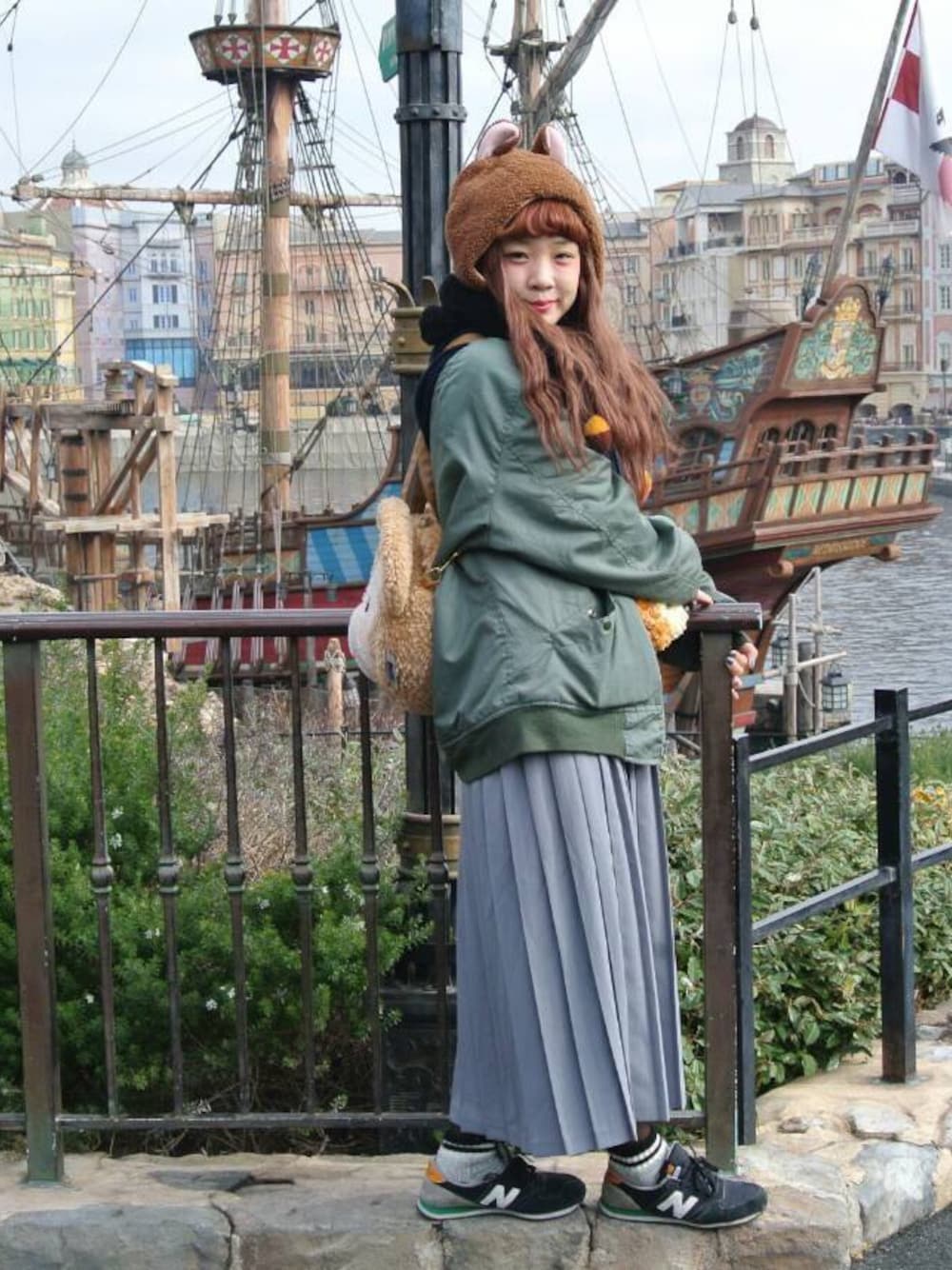 グレー系のニット/セーター、グリーン系のナイロンジャケット、グレー系のスカートを着用したレディースの冬コーディネートの1枚目の写真