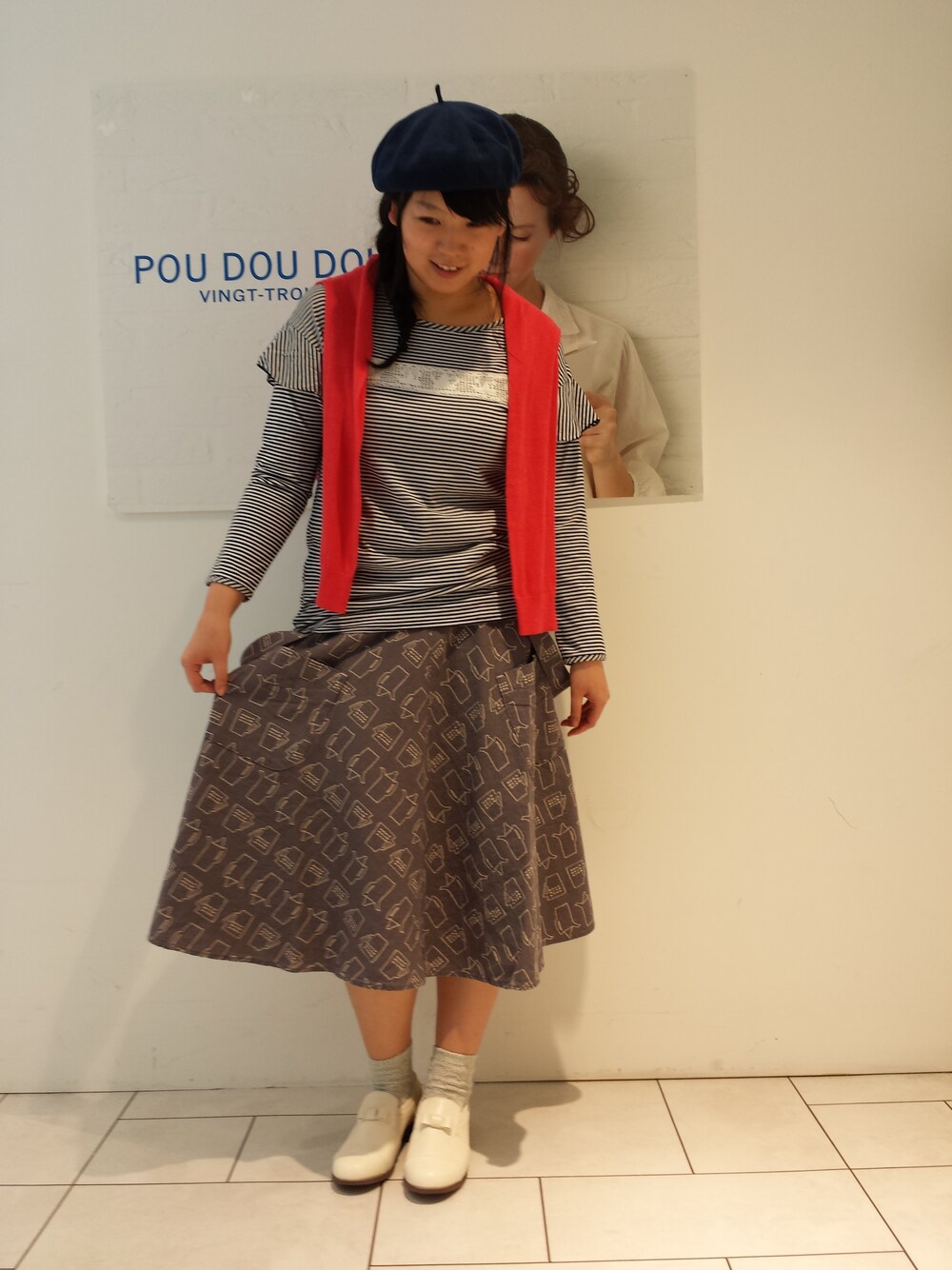 ホワイト系のその他シューズ、ブルー系のTシャツ/カットソー、レッド系のカーディガン/ボレロを着用したレディースの冬コーディネートの1枚目の写真