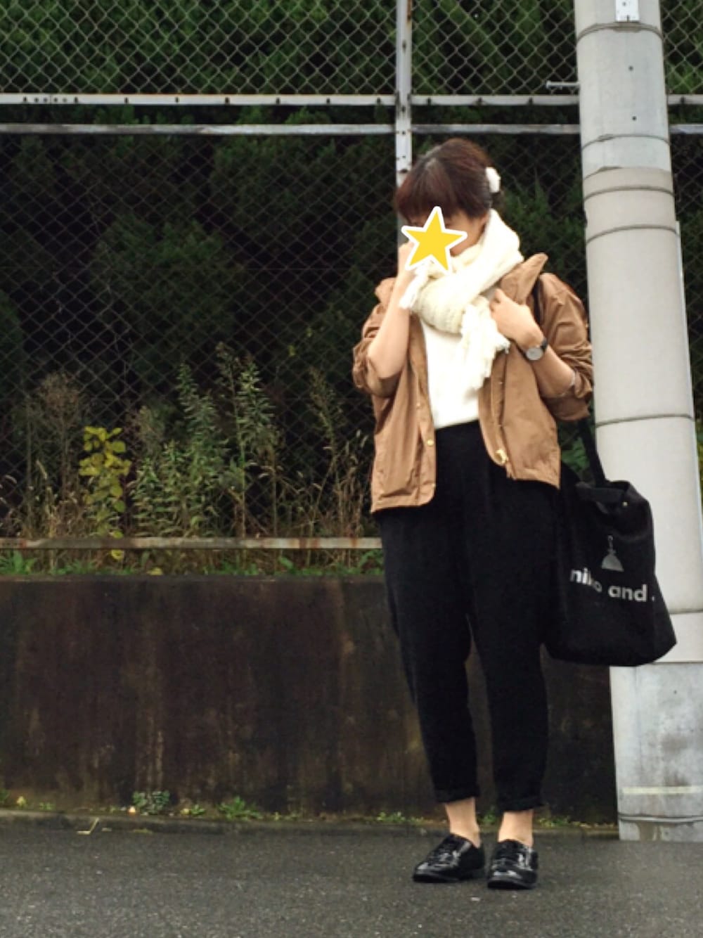 ブラウン系のマウンテンパーカー、ホワイト系のトップス、ブラック系のパンツを着用したレディースの冬コーディネートの1枚目の写真