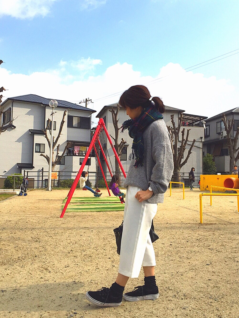 グレー系のニット/セーター、ホワイト系のパンツ、ブラック系のスニーカーを着用したレディースの冬コーディネートの1枚目の写真