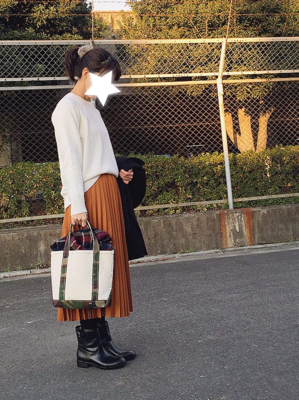 ホワイト系のトップス、ブラウン系のスカート、ブラック系のダウンジャケット/コートを着用したレディースの冬コーディネートの1枚目の写真