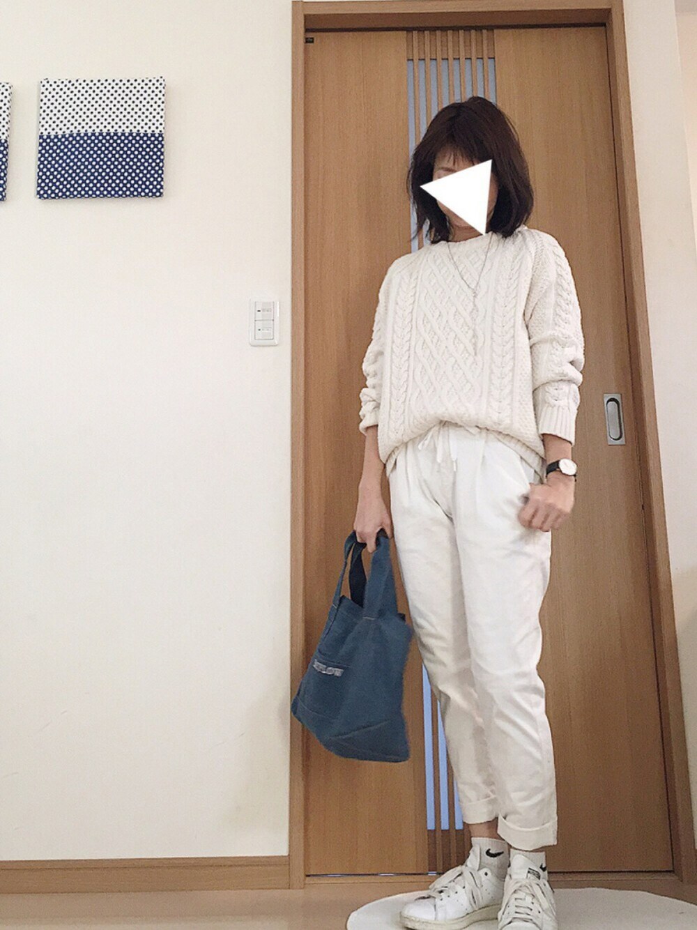ホワイト系のニット/セーター、ホワイト系のチノパンツ、ブルー系のトートバッグを着用したレディースの冬コーディネートの1枚目の写真