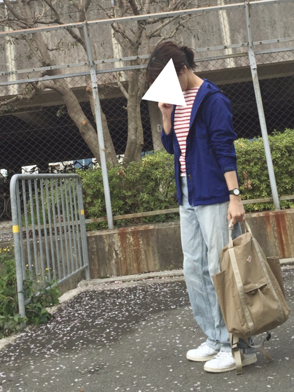 ブルー系のマウンテンパーカー、レッド系のトップス、ブルー系のデニムパンツを着用したレディースの春コーディネートの1枚目の写真