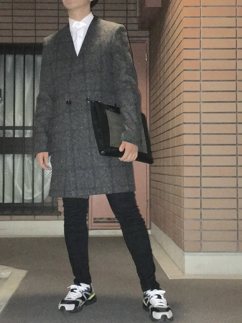 グレー系のダウンジャケット/コート、ブラック系のクラッチバッグ、ブラック系のパンツを着用したメンズの冬コーディネートの1枚目の写真