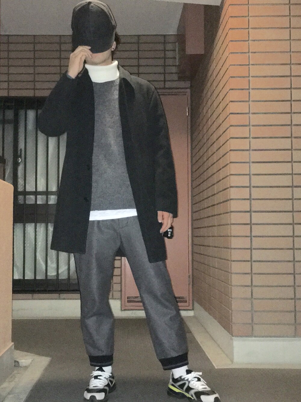 ホワイト系のニット/セーター、グレー系のパンツ、ベージュ系のスニーカーを着用したメンズの冬コーディネートの1枚目の写真