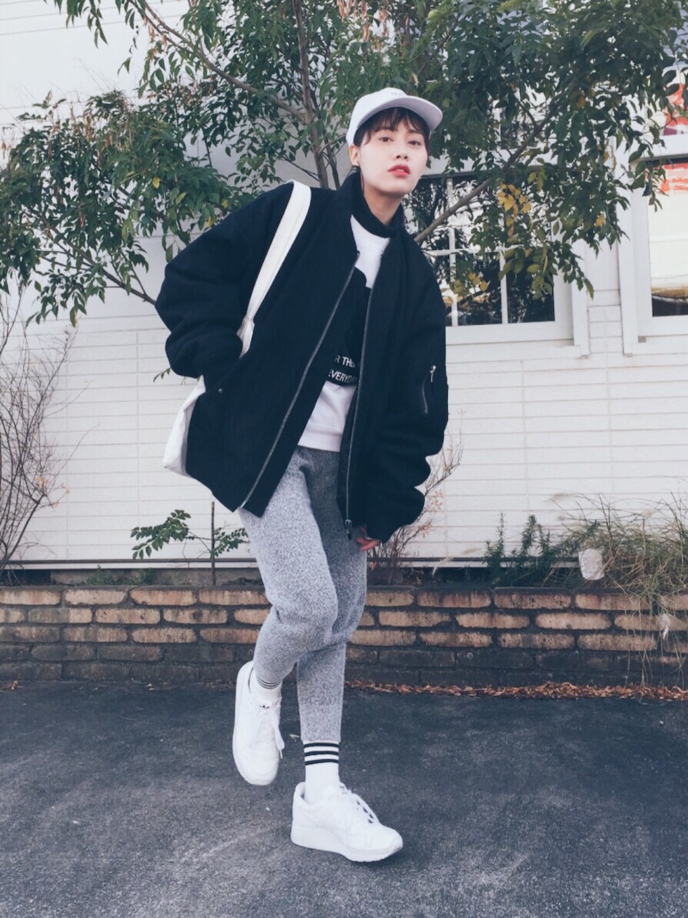 ブラック系のMA-1、ホワイト系のスウェット、ブラック系のTシャツ/カットソーを着用したレディースの冬コーディネートの1枚目の写真