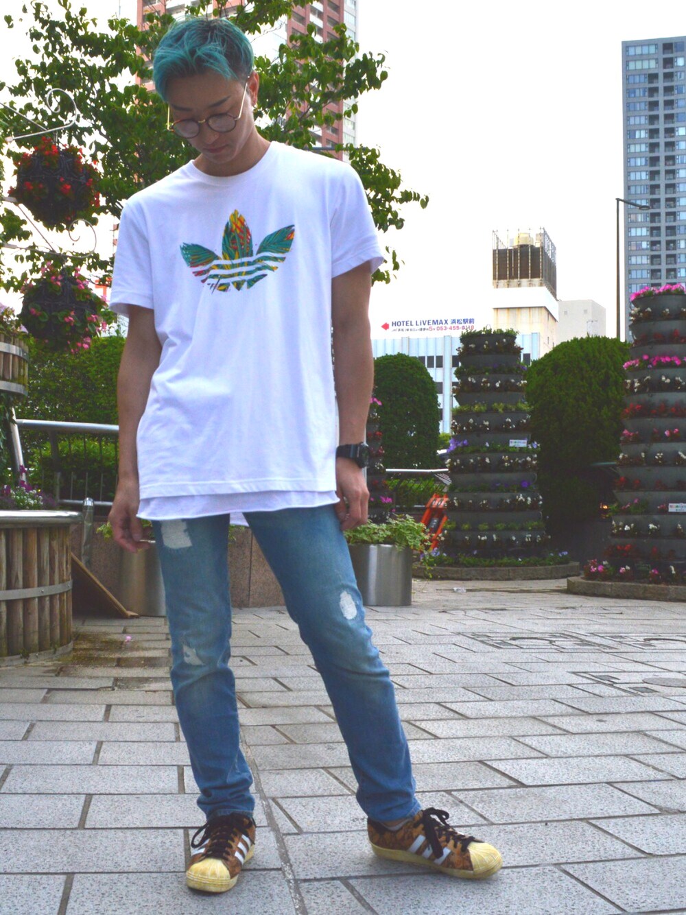 ホワイト系のTシャツ/カットソー、ブラウン系のスニーカー、ブルー系のデニムパンツを着用したメンズの春コーディネートの1枚目の写真