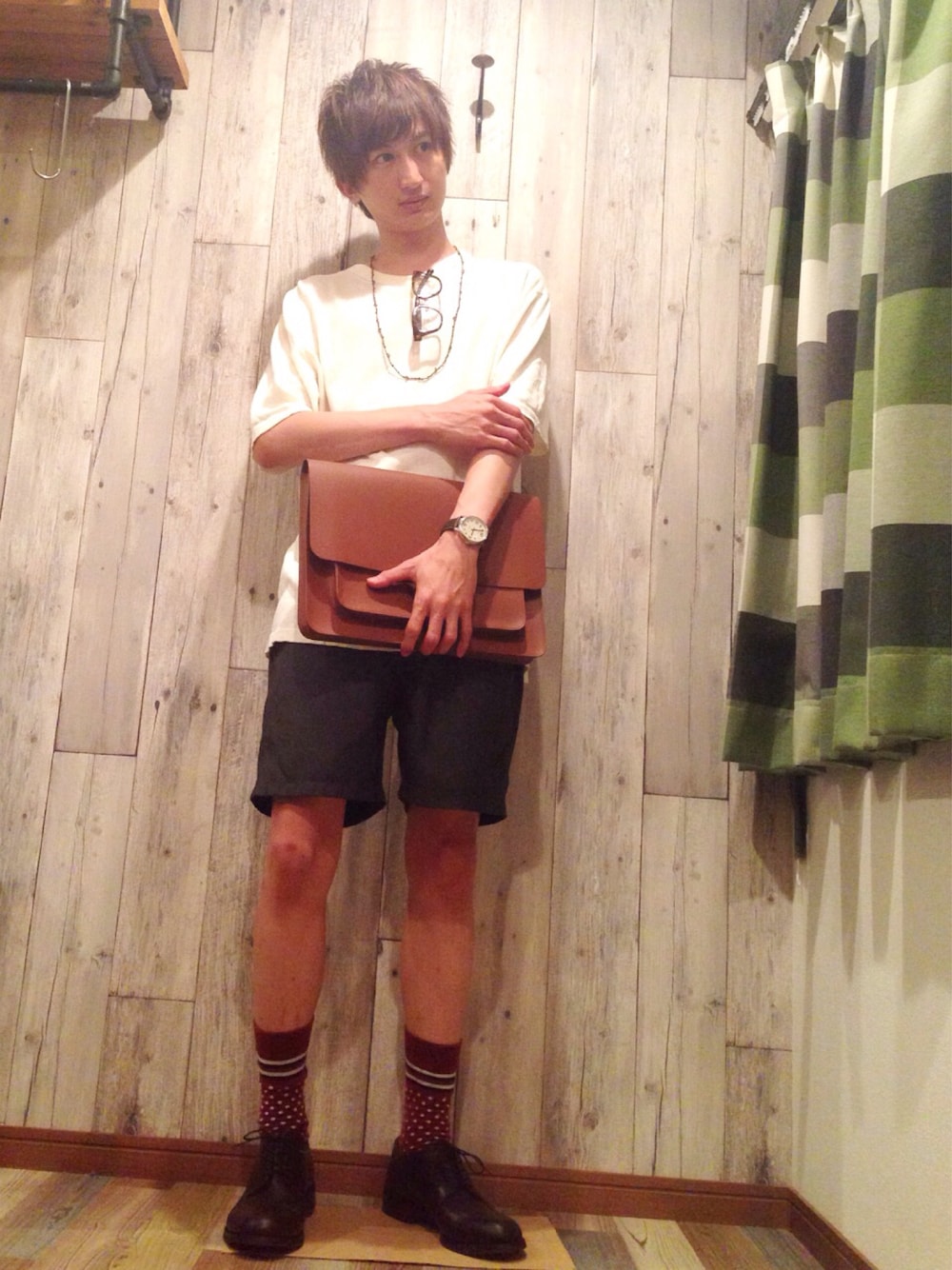 ホワイト系のニット/セーター、ブラウン系のドレスシューズ、ブラウン系のクラッチバッグを着用したメンズの夏コーディネートの1枚目の写真