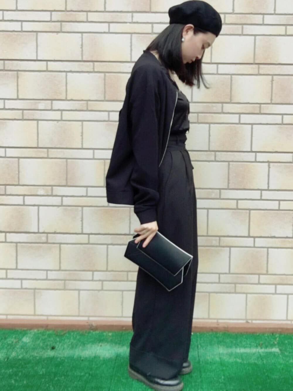 ブラック系のパンツ、ブラック系のクラッチバッグ、ブラック系のドレスシューズを着用したレディースの夏コーディネートの1枚目の写真