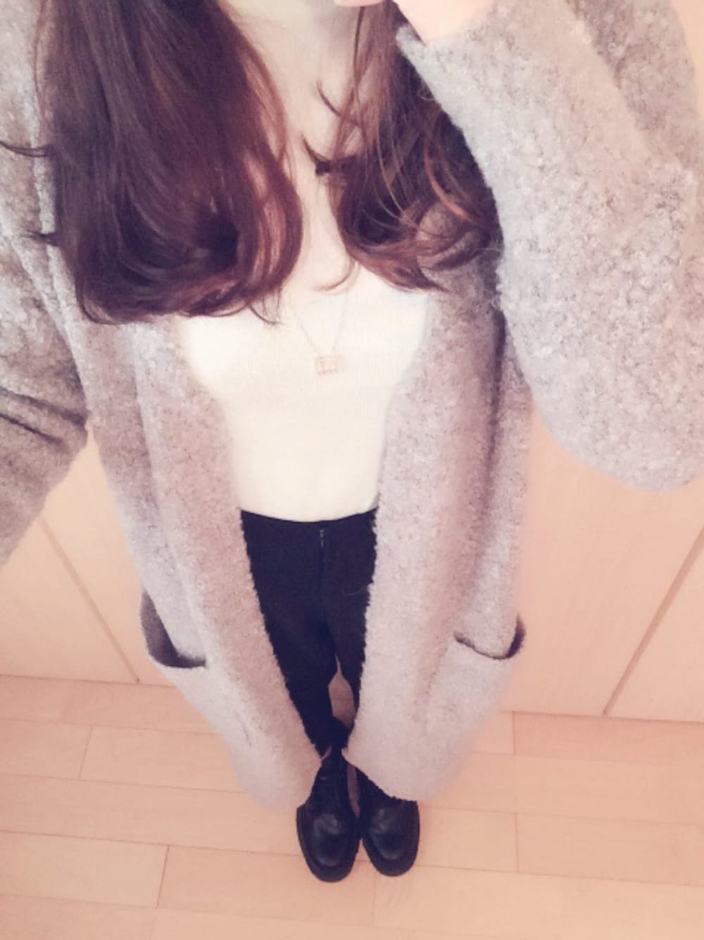 グレー系のカーディガン/ボレロ、ホワイト系のニット/セーター、ブラック系のブーツを着用したレディースの冬コーディネートの1枚目の写真