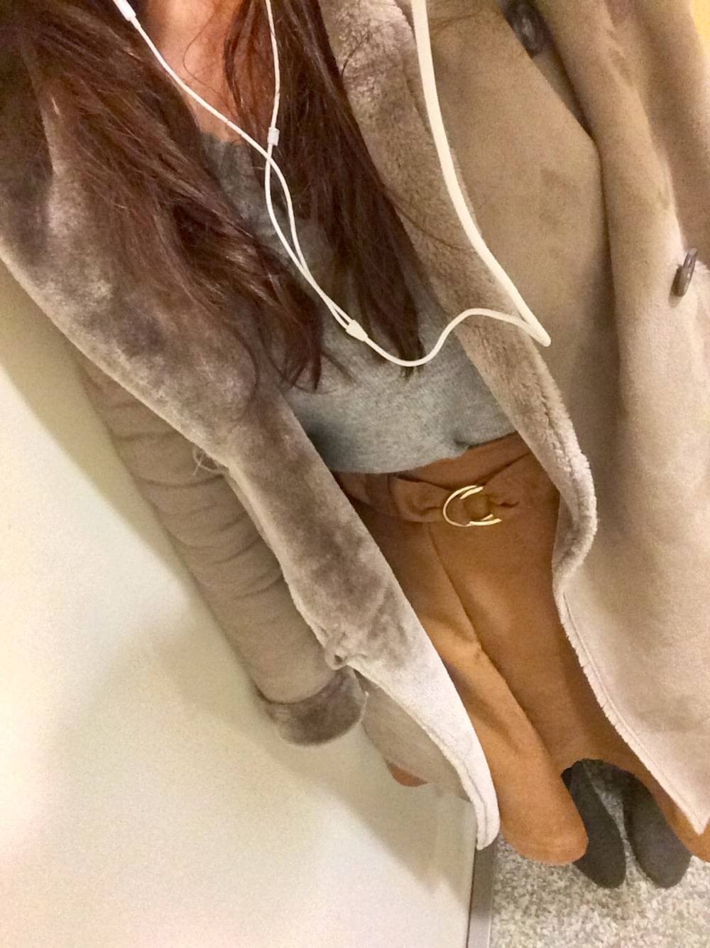 グレー系のニット/セーター、グレー系のムートンコート、イエロー系のスカートを着用したレディースの冬コーディネートの1枚目の写真