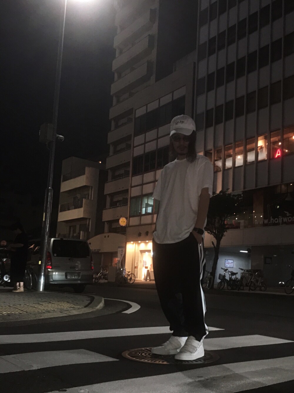 ホワイト系のスニーカー、ブラック系のパンツ、ホワイト系のTシャツ/カットソーを着用したメンズの夏コーディネートの1枚目の写真