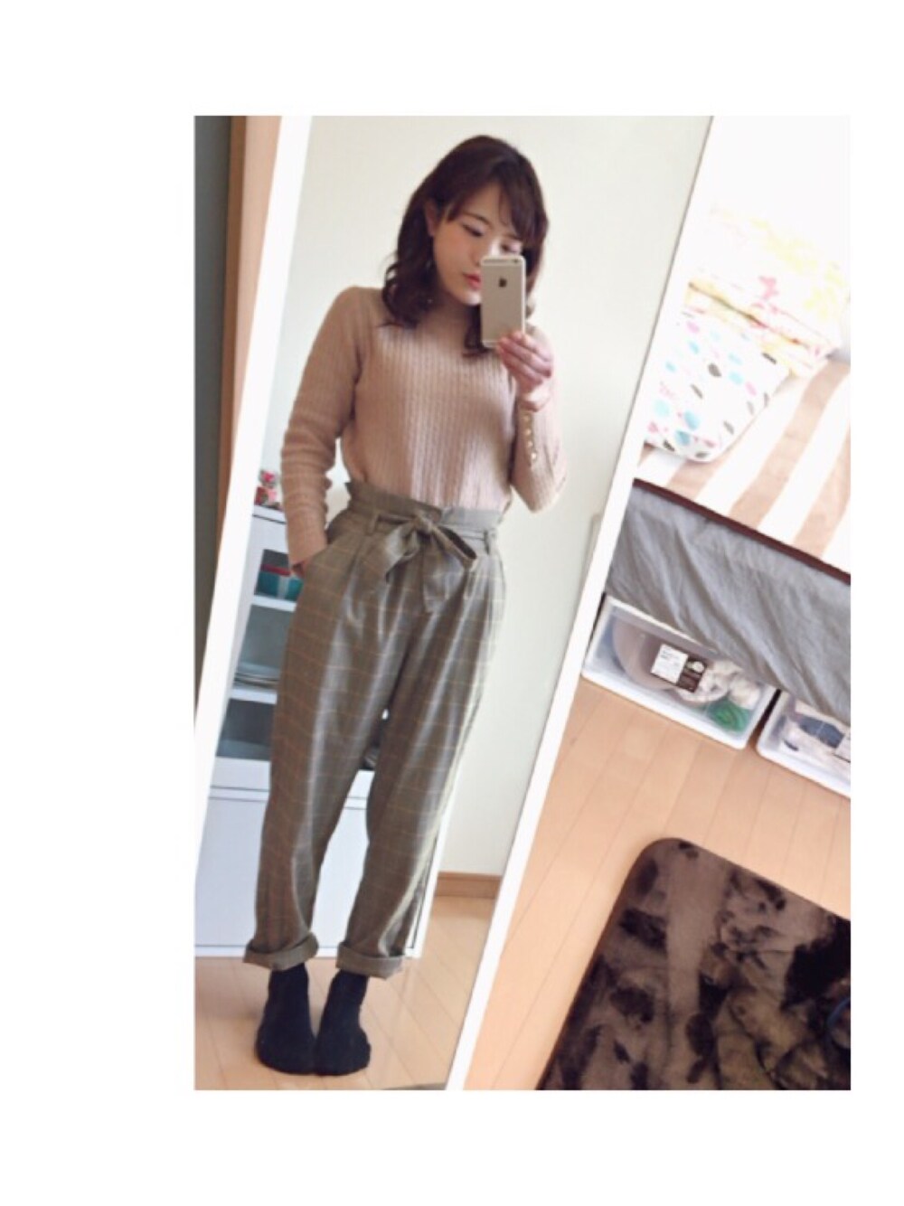 ピンク系のニット/セーター、ブラウン系のスラックスを着用したレディースの冬コーディネートの1枚目の写真