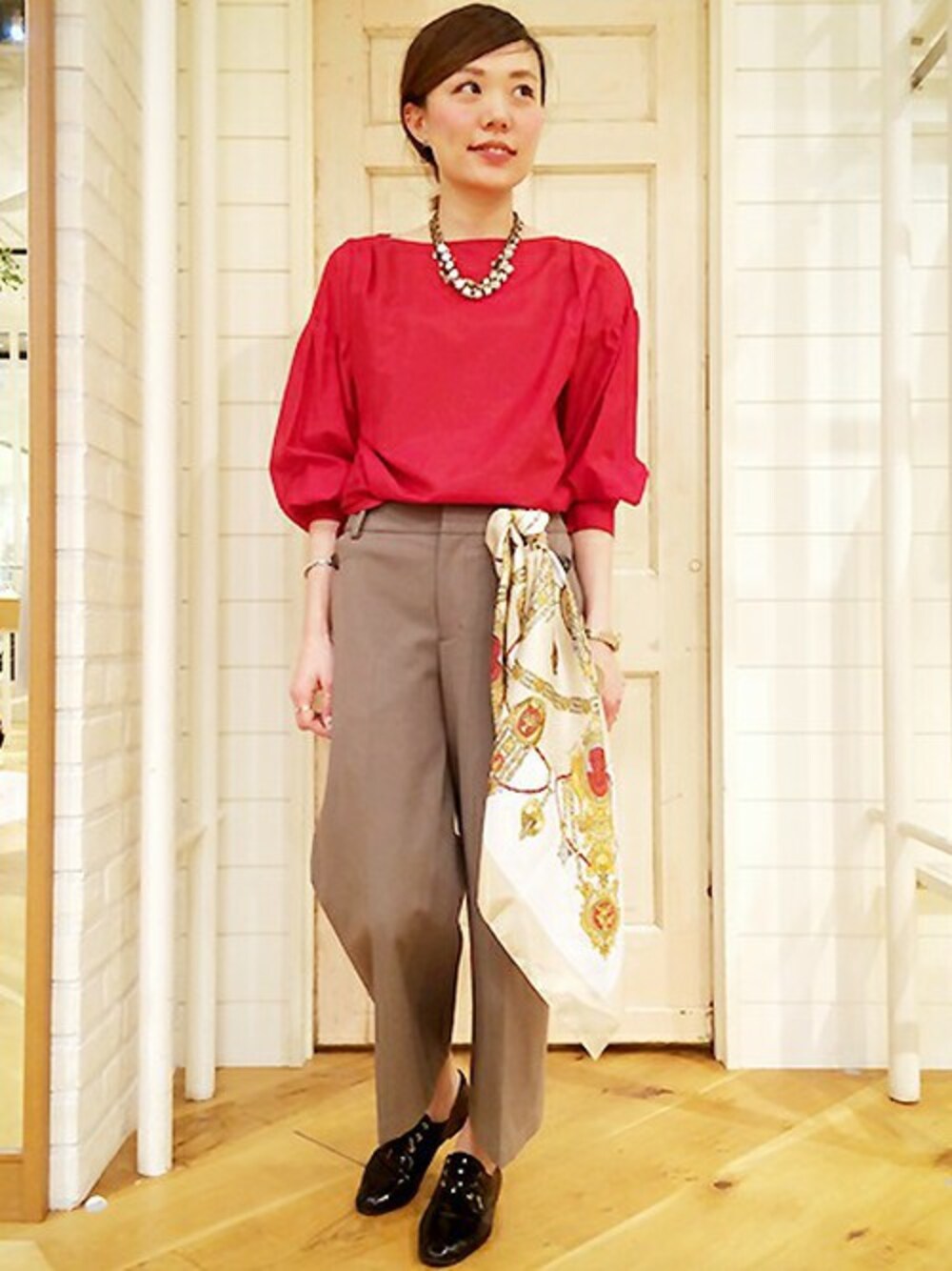 レッド系のシャツ/ブラウス、グリーン系のチノパンツを着用したレディースの春コーディネートの1枚目の写真