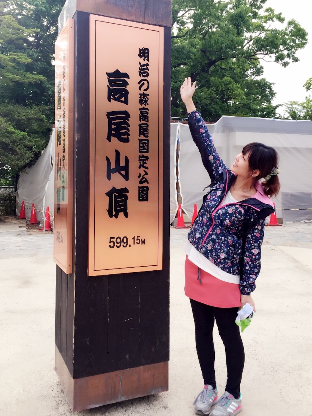 ブルー系のナイロンジャケット、グレー系のスニーカー、ピンク系のスカートを着用したレディースの春コーディネートの1枚目の写真