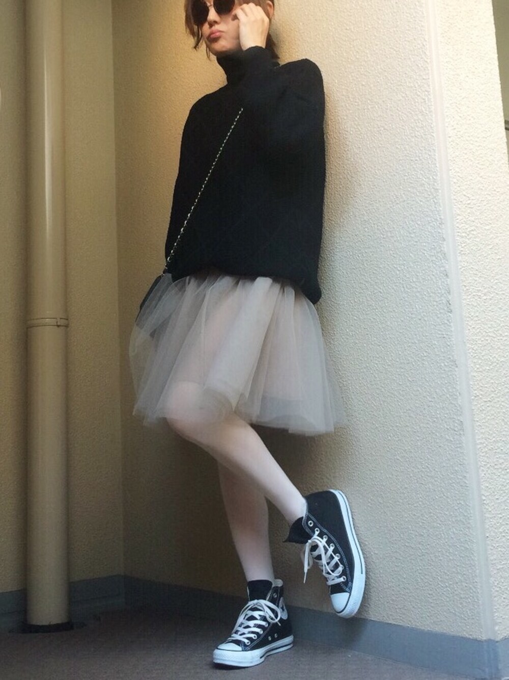 ブラック系のニット/セーター、グレー系のワンピース、ブラック系のスニーカーを着用したレディースの冬コーディネートの1枚目の写真