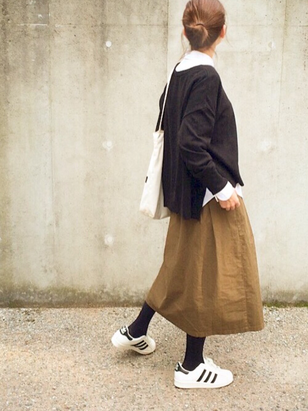 ホワイト系のトップス、ブラック系のニット/セーター、ホワイト系のトートバッグを着用したレディースの秋コーディネートの1枚目の写真