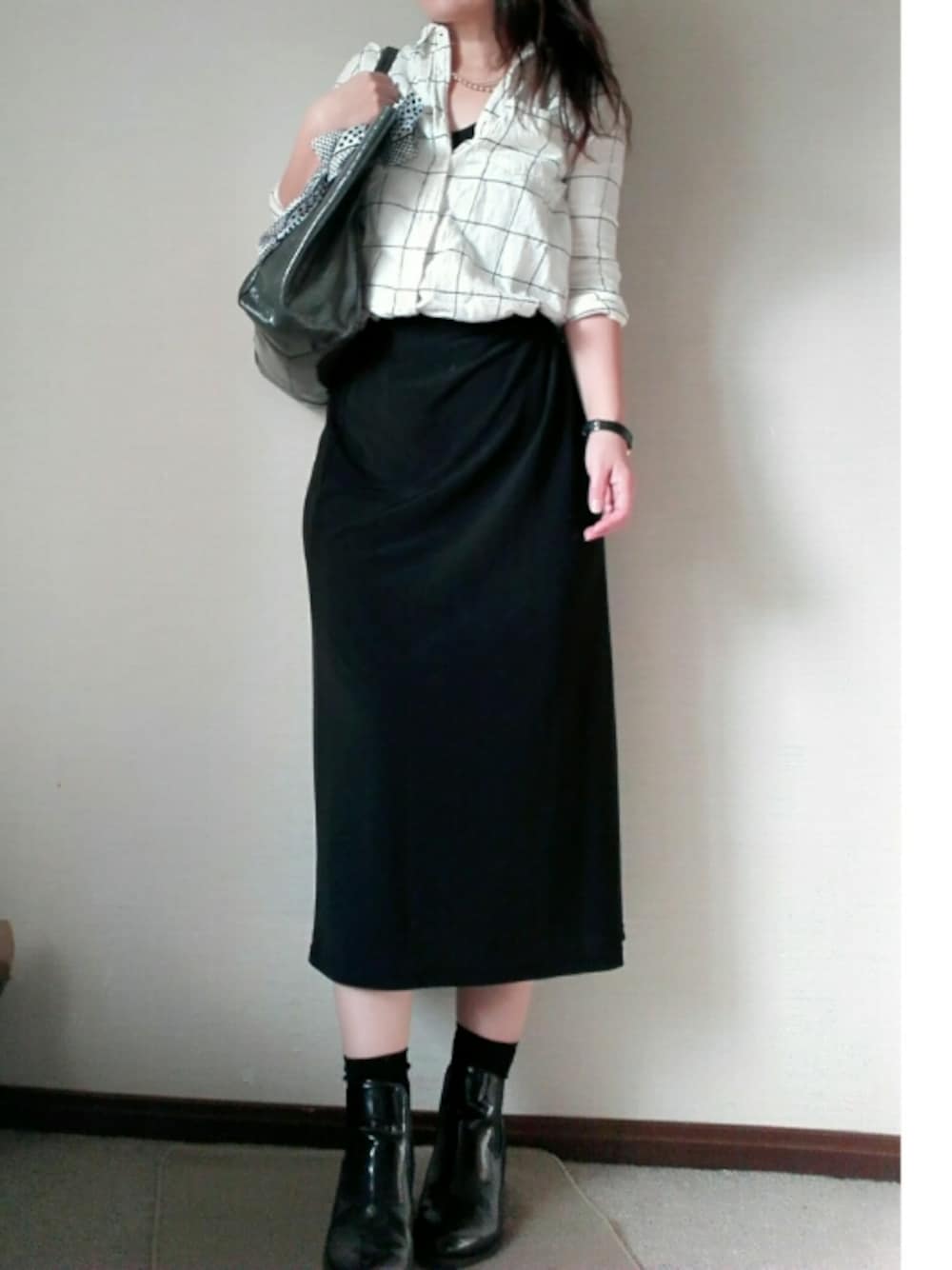 ブラック系のシューズ、ホワイト系のトップス、ブラック系のスカートを着用したレディースの秋コーディネートの1枚目の写真