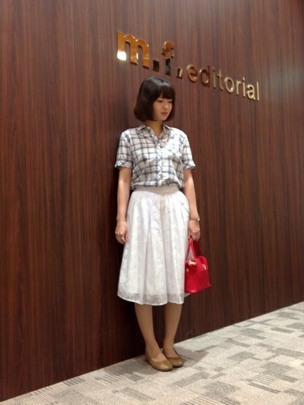 ブルー系のチュニック、ホワイト系のスカートを着用したレディースの夏コーディネートの1枚目の写真