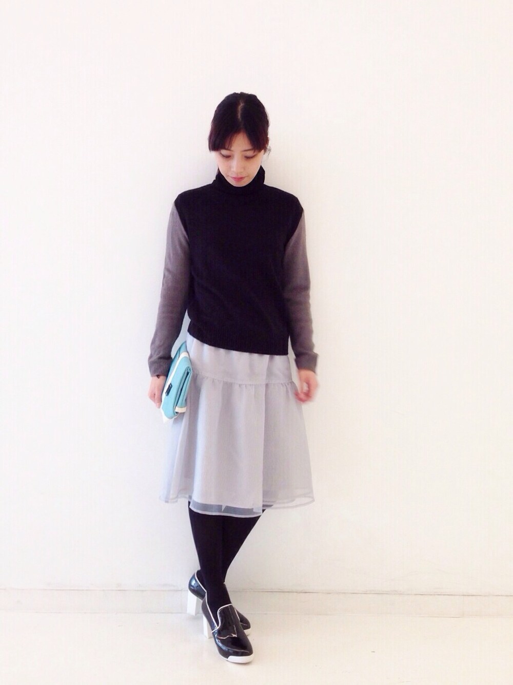ブラック系のニット/セーター、ベージュ系のニット/セーター、グレー系のスカートを着用したレディースの冬コーディネートの1枚目の写真