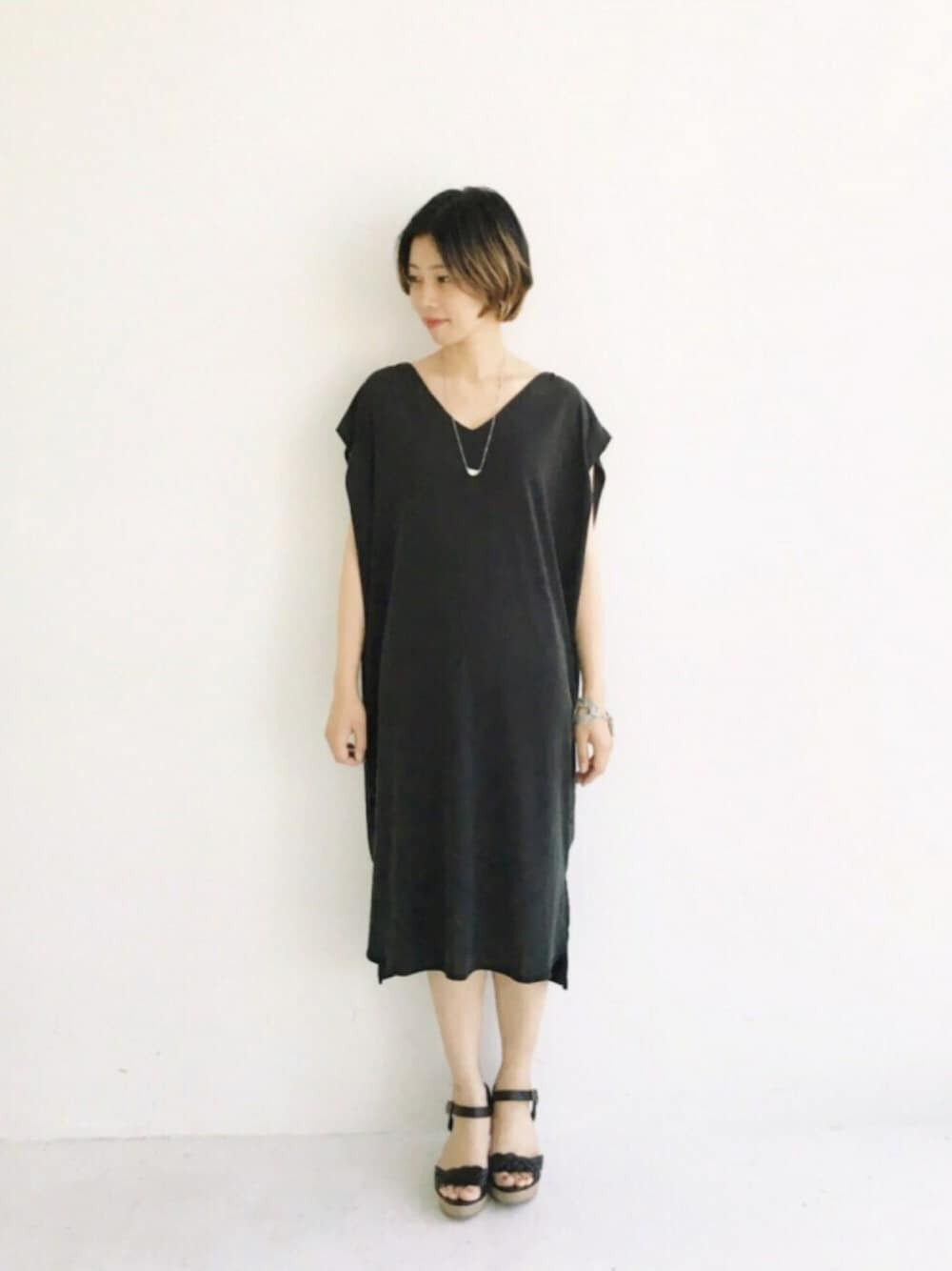 ブラック系のワンピース、ブラック系のサンダルを着用したレディースの春コーディネートの1枚目の写真