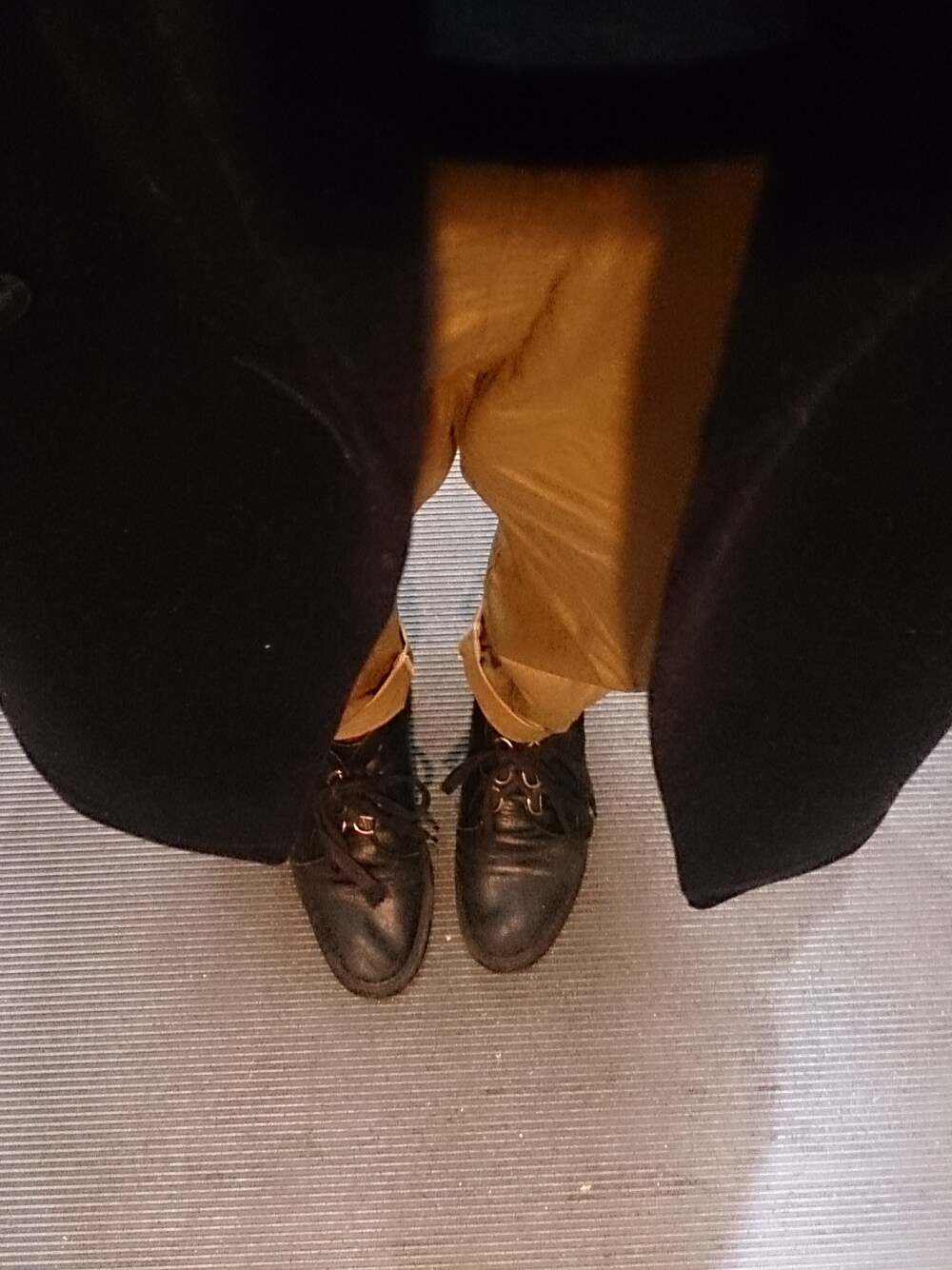 ベージュ系のチノパンツ、ブラック系のジャケット/アウター、ブルー系のニット/セーターを着用したレディースの秋コーディネートの1枚目の写真