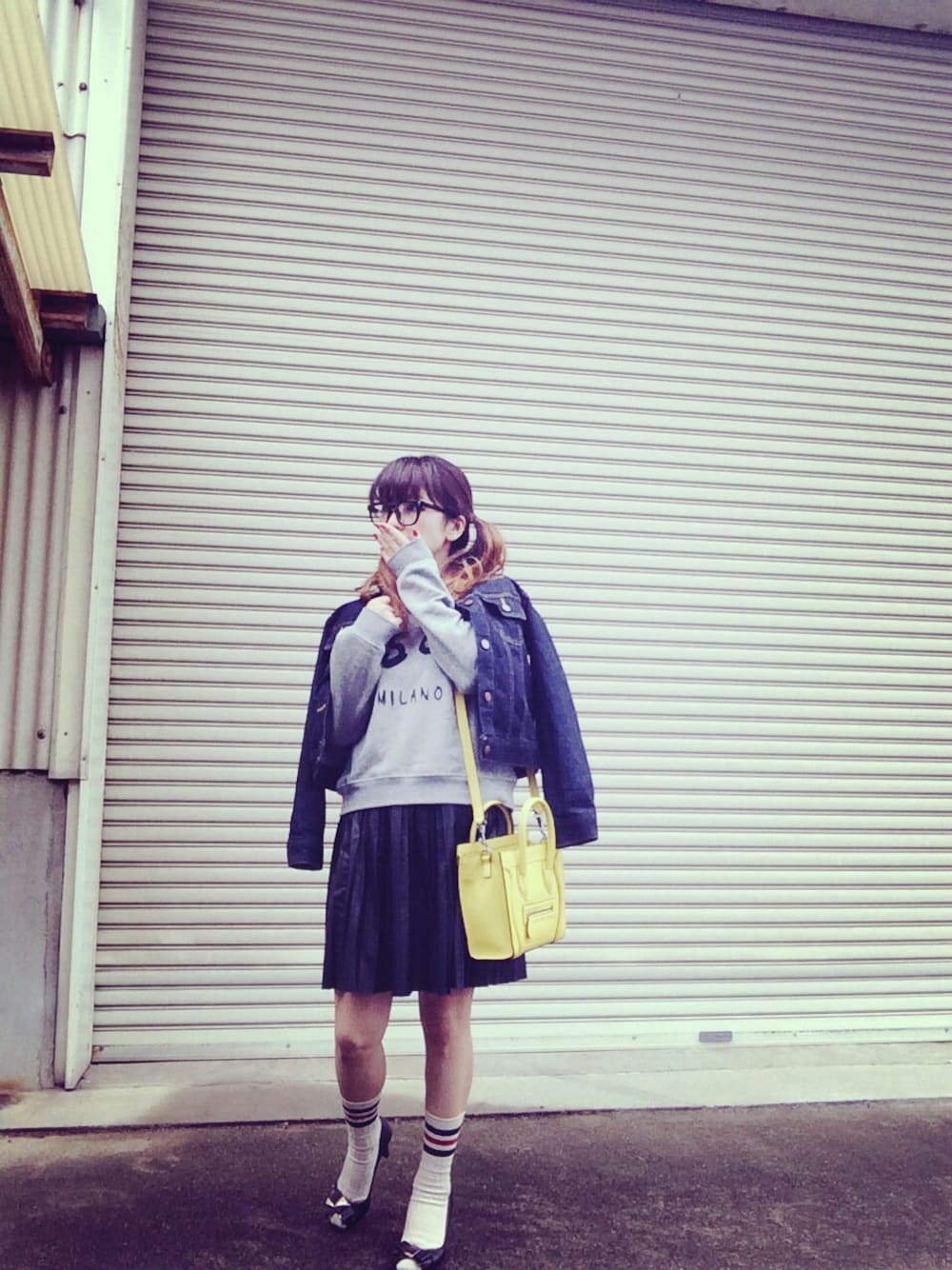 ブルー系のデニムジャケット、グレー系のスウェット、イエロー系のショルダーバッグを着用したレディースの春コーディネートの1枚目の写真