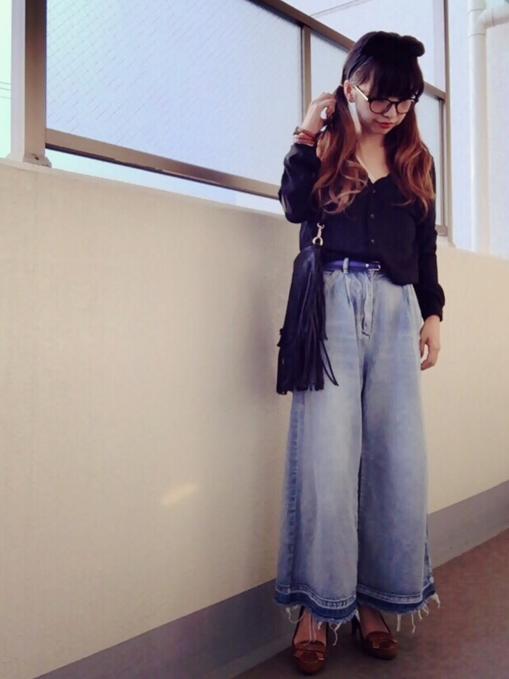 ブラック系のシャツ/ブラウス、ブラック系のショルダーバッグ、ブルー系のデニムパンツを着用したレディースの秋コーディネートの1枚目の写真