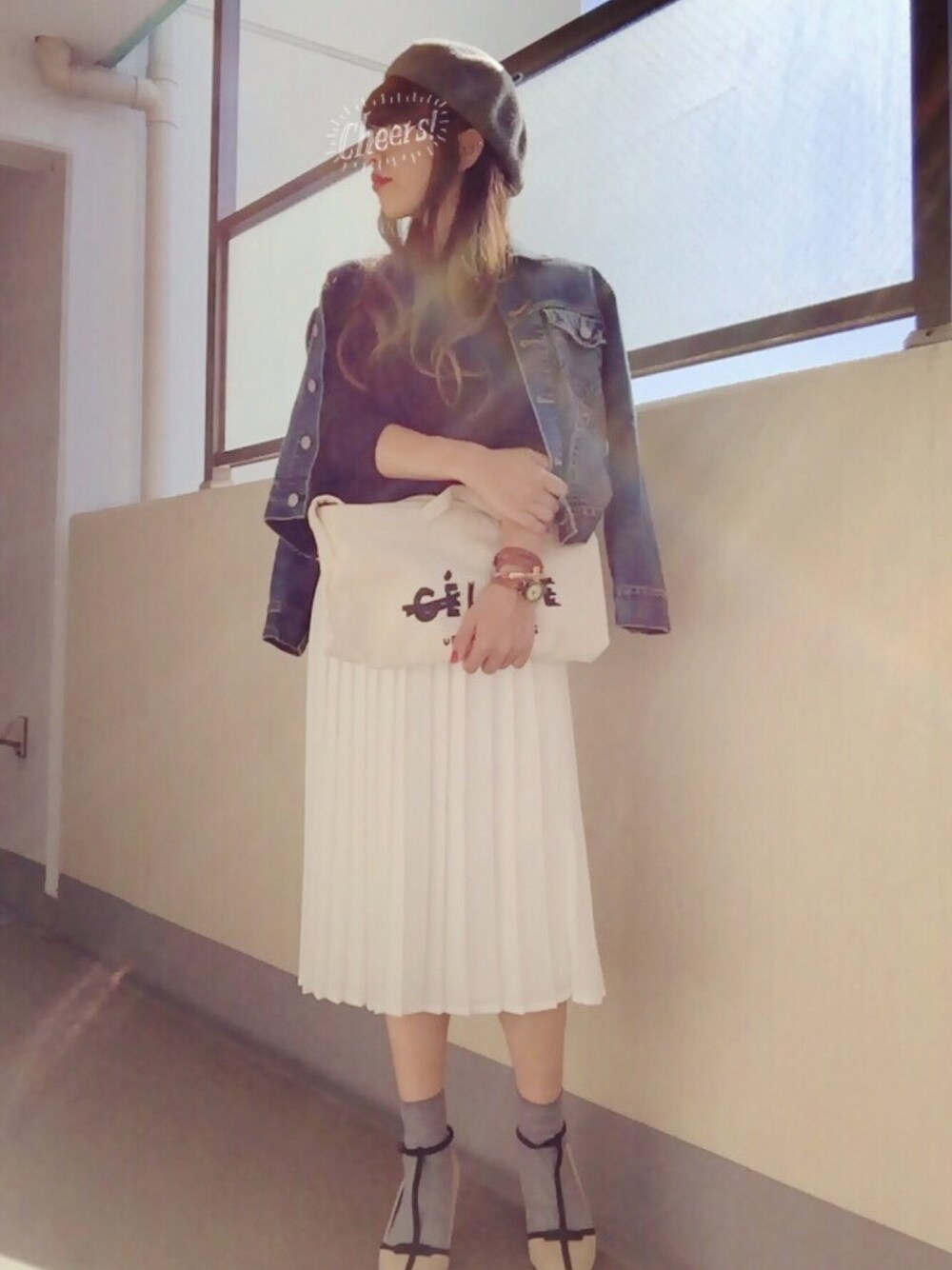 ブルー系のデニムジャケット、ホワイト系のクラッチバッグ、ホワイト系のスカートを着用したレディースの秋コーディネートの1枚目の写真