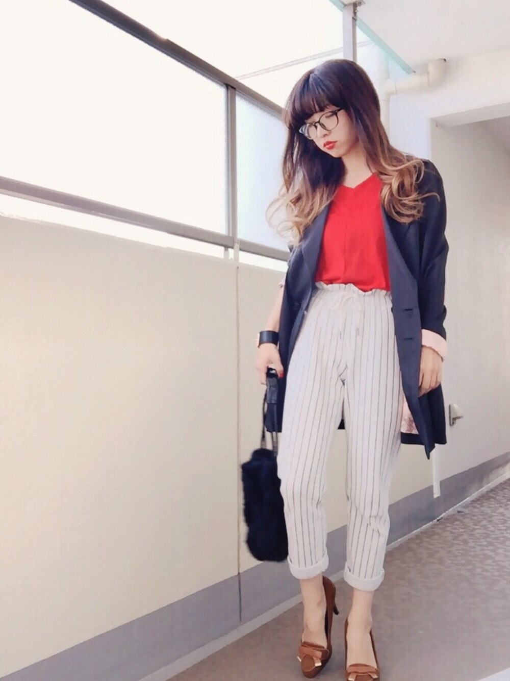 レッド系のニット/セーター、ブラック系のトレンチコート、ホワイト系のその他パンツを着用したレディースの秋コーディネートの1枚目の写真