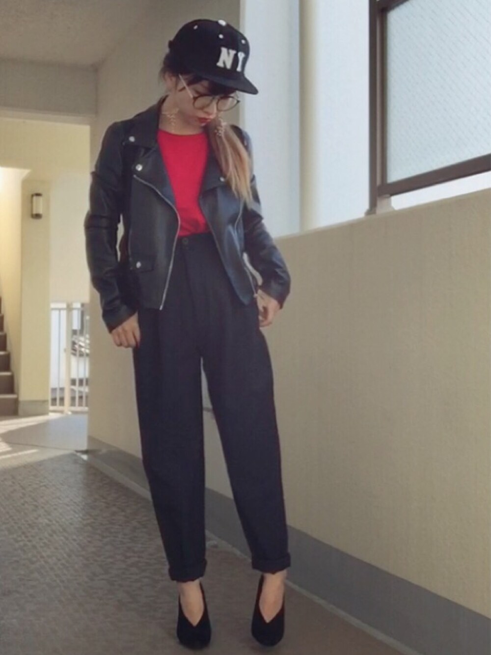 レッド系のニット/セーター、ブラック系のライダースジャケット、ブラック系のトートバッグを着用したレディースの冬コーディネートの1枚目の写真