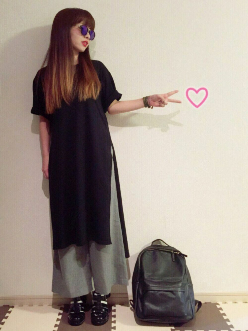 ブラック系のTシャツ/カットソー、ブラック系のバックパック/リュック、ブラック系のサンダルを着用したレディースの春コーディネートの1枚目の写真