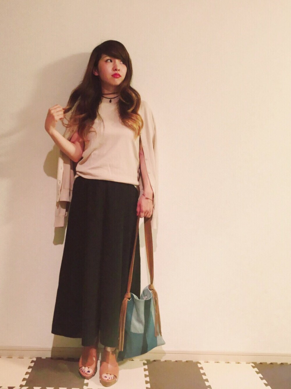 ベージュ系のカーディガン/ボレロ、ベージュ系のタンクトップ、ブラック系のパンツを着用したレディースの春コーディネートの1枚目の写真