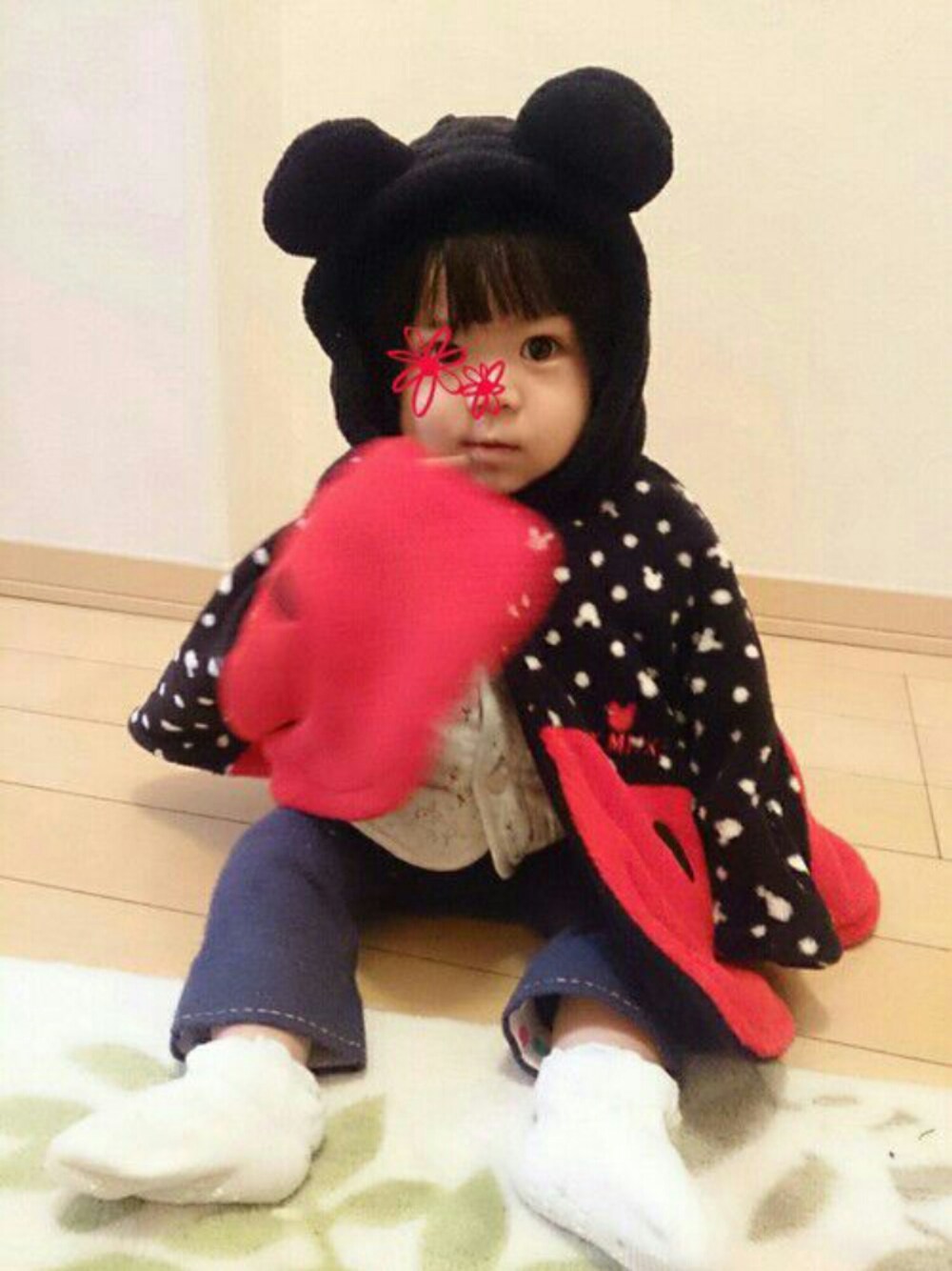 ブラック系のポンチョを着用したキッズの冬コーディネートの1枚目の写真