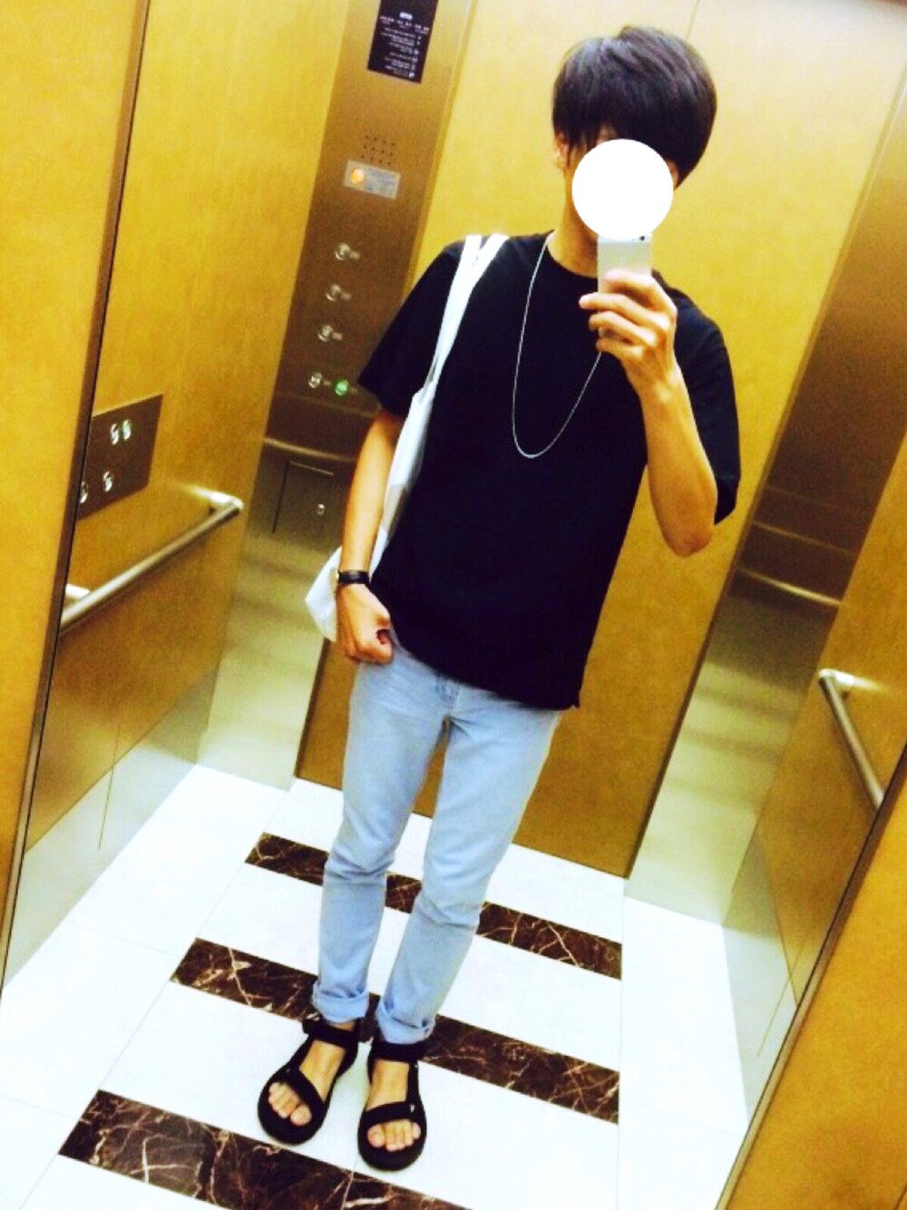 ブラック系のTシャツ/カットソー、ブルー系のデニムパンツ、ブラック系のサンダルを着用したメンズの夏コーディネートの1枚目の写真