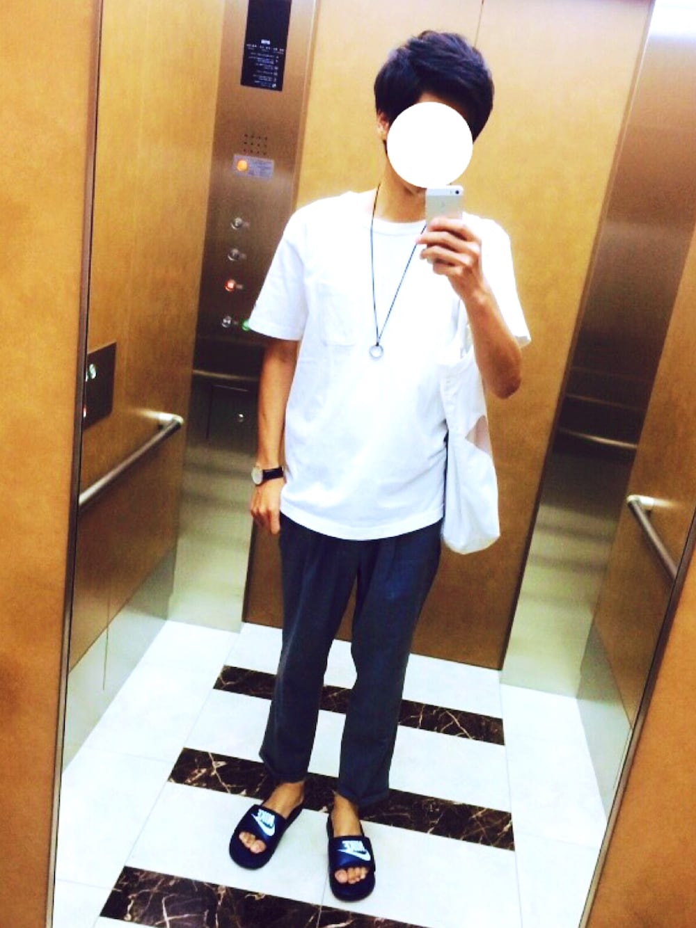 ホワイト系のTシャツ/カットソー、グレー系のスラックス、ブルー系のサンダルを着用したメンズの夏コーディネートの1枚目の写真