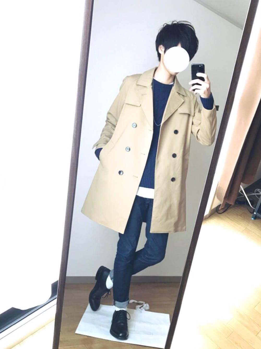 ベージュ系のトレンチコート、ブルー系のニット/セーター、ホワイト系のTシャツ/カットソーを着用したメンズの秋コーディネートの1枚目の写真