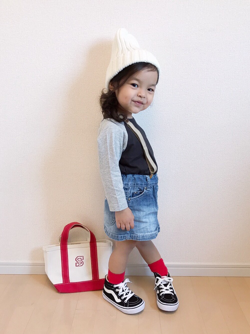 ブラック系のスニーカー、ブラック系のTシャツ/カットソー、ブルー系のデニムスカートを着用したキッズの秋コーディネートの1枚目の写真