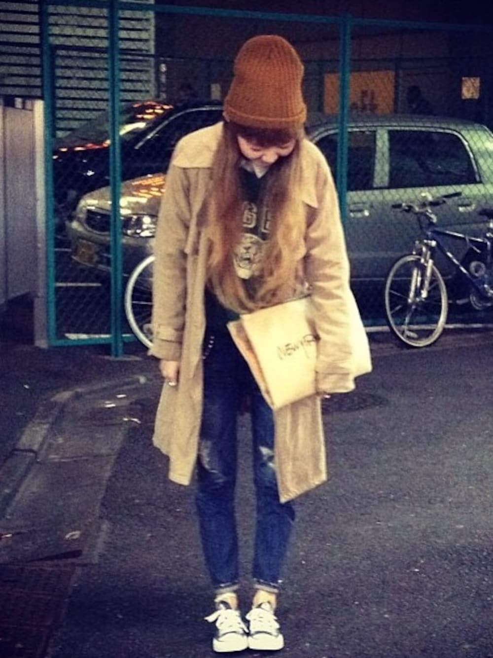 グリーン系のスウェット、ホワイト系のシャツ/ブラウス、ベージュ系のクラッチバッグを着用したレディースの秋コーディネートの1枚目の写真