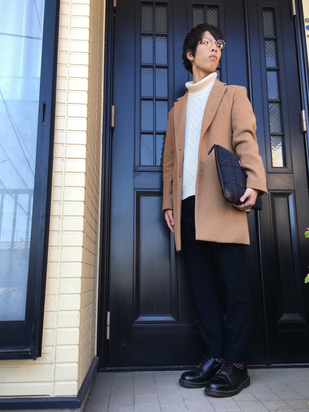イエロー系のステンカラーコート、ホワイト系のニット/セーター、ブルー系のスラックスを着用したメンズの冬コーディネートの1枚目の写真