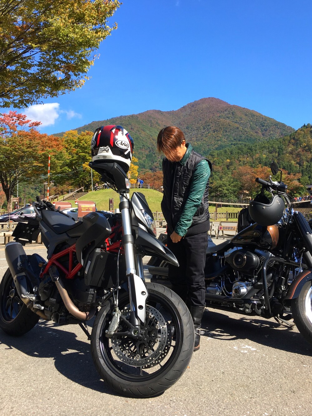 ブルー系のライダースジャケット、ブラック系のブーツ、ブラック系のダウンベストを着用したメンズの秋コーディネートの1枚目の写真