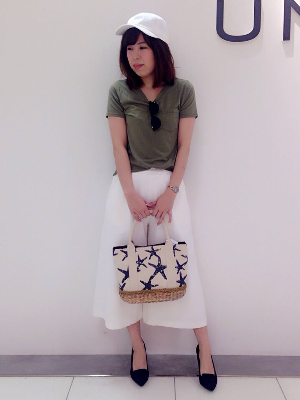 ホワイト系のその他パンツ、ブラック系のパンプス、グリーン系のTシャツ/カットソーを着用したレディースの春コーディネートの1枚目の写真