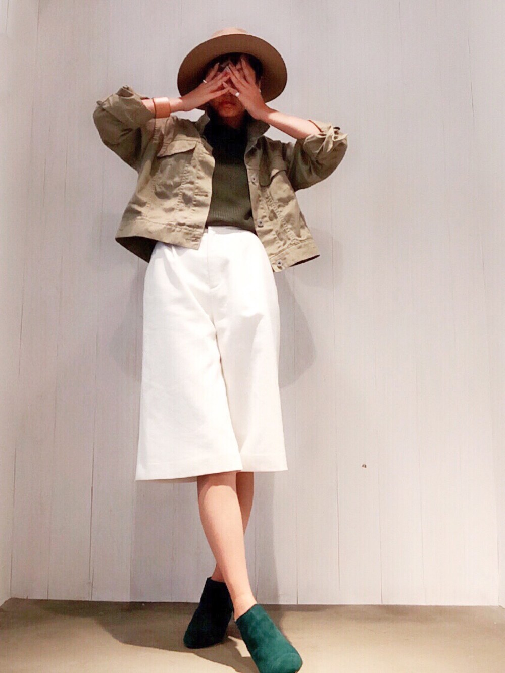 グリーン系のジャケット/アウター、グリーン系のニット/セーター、ホワイト系のパンツを着用したレディースの秋コーディネートの1枚目の写真