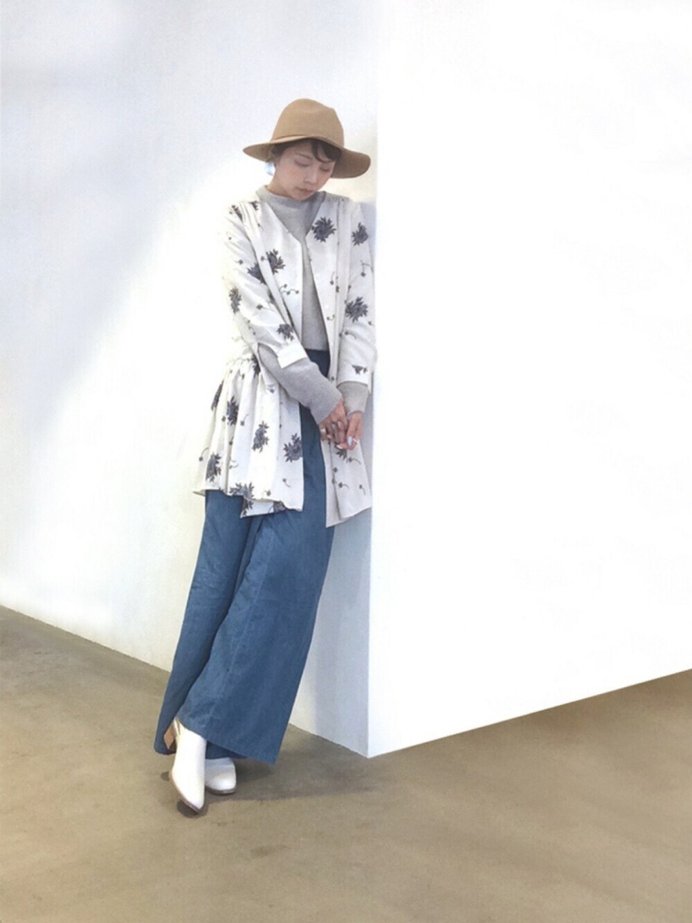 グレー系のニット/セーター、ブルー系のその他パンツ、ホワイト系のパンプスを着用したレディースの冬コーディネートの1枚目の写真