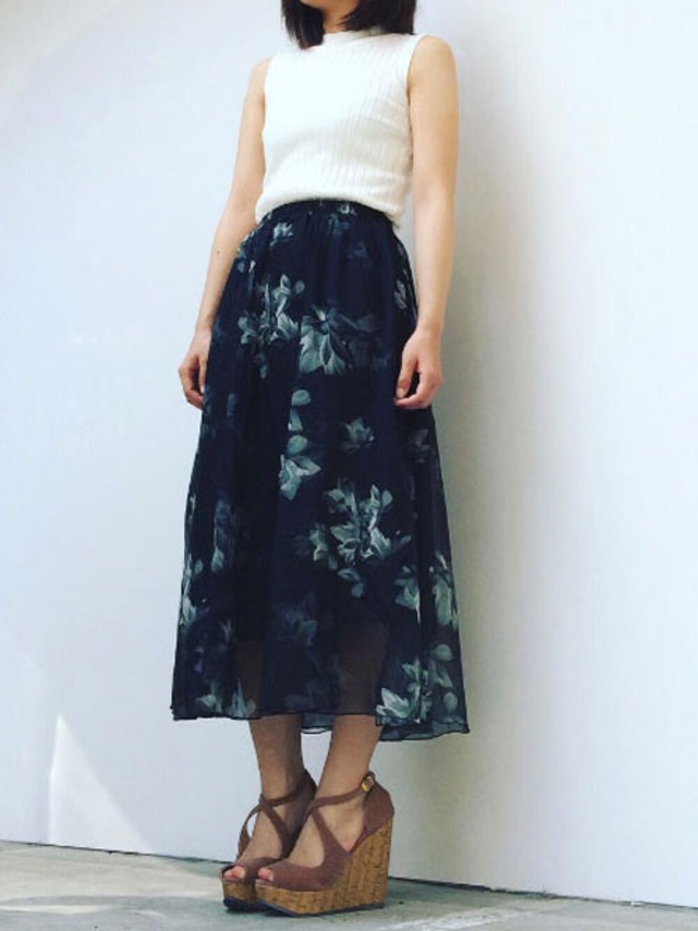 ホワイト系のタンクトップ、ブラック系のスカートを着用したレディースの春コーディネートの1枚目の写真