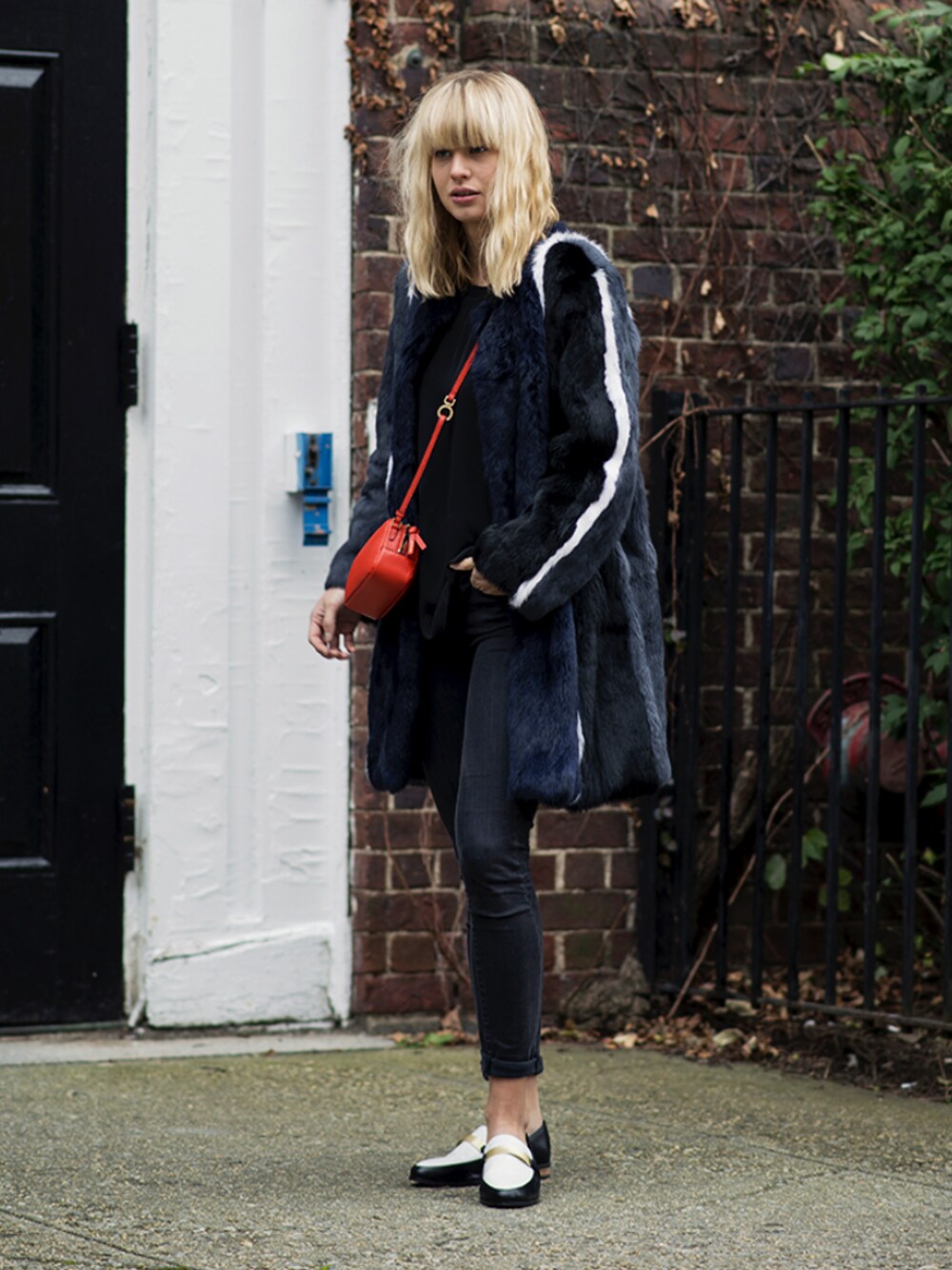 レッド系のショルダーバッグ、ホワイト系のドレスシューズを着用したレディースの秋コーディネートの1枚目の写真