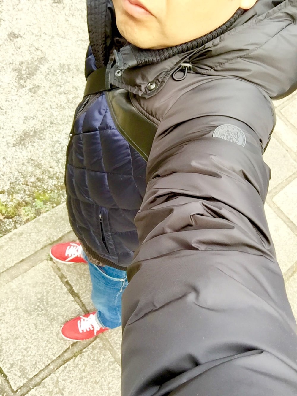 ブルー系のダウンジャケット/コート、ブルー系のデニムパンツ、レッド系のスニーカーを着用したメンズの冬コーディネートの1枚目の写真