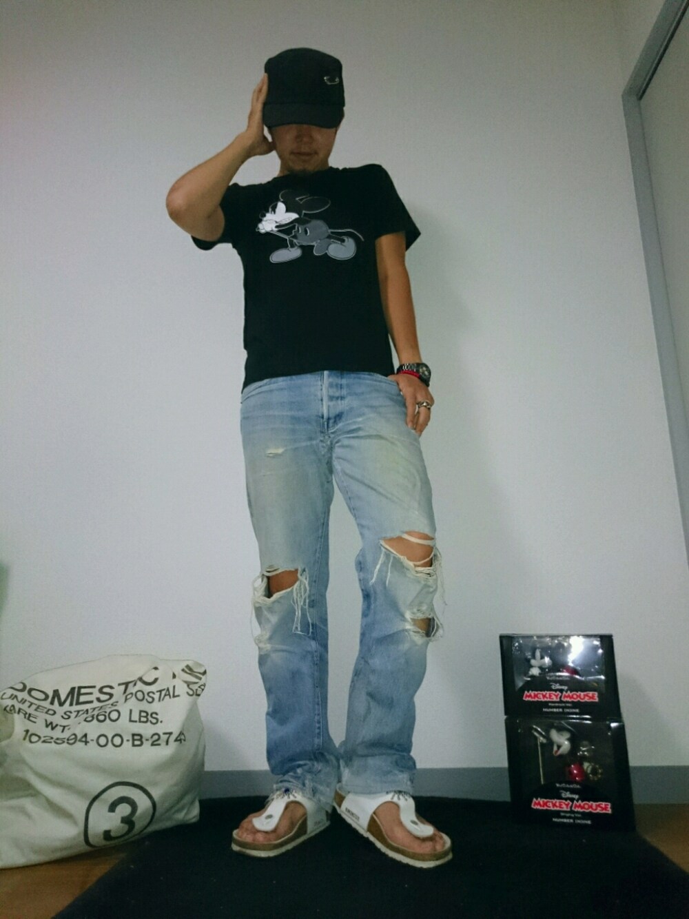 ホワイト系のサンダル、ブラック系のTシャツ/カットソー、ブルー系のパンツを着用したメンズの夏コーディネートの1枚目の写真