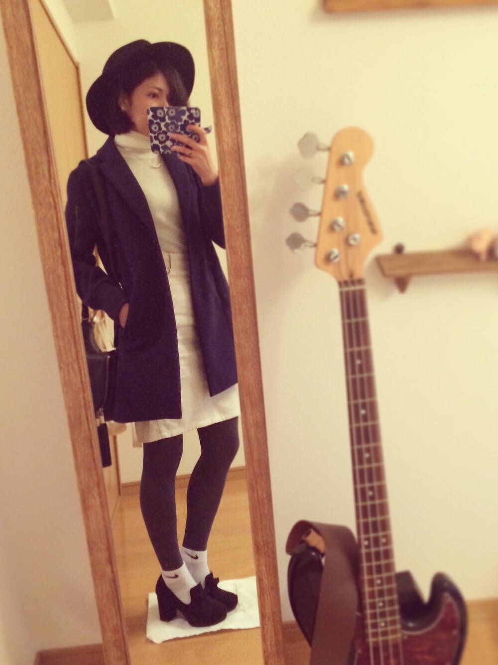 ブルー系のチェスターコート、ホワイト系のニット/セーター、ホワイト系のデニムスカートを着用したレディースの冬コーディネートの1枚目の写真