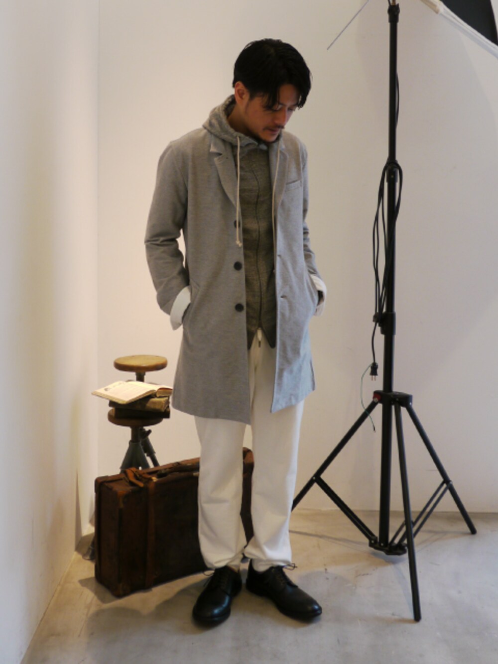 グレー系のチェスターコート、グレー系のパーカー、ホワイト系のその他パンツを着用したメンズの夏コーディネートの1枚目の写真